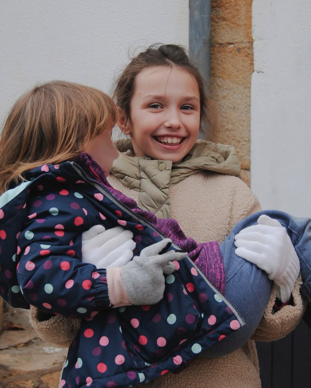Older student holding younger student